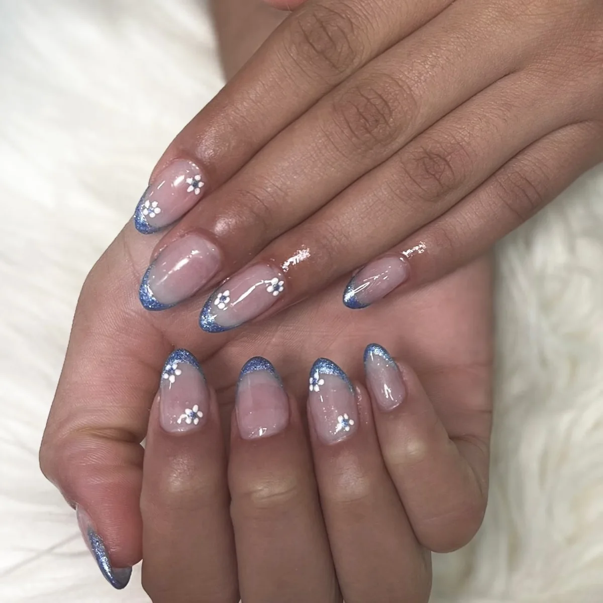 Nail art azul com pequenas flores brancas