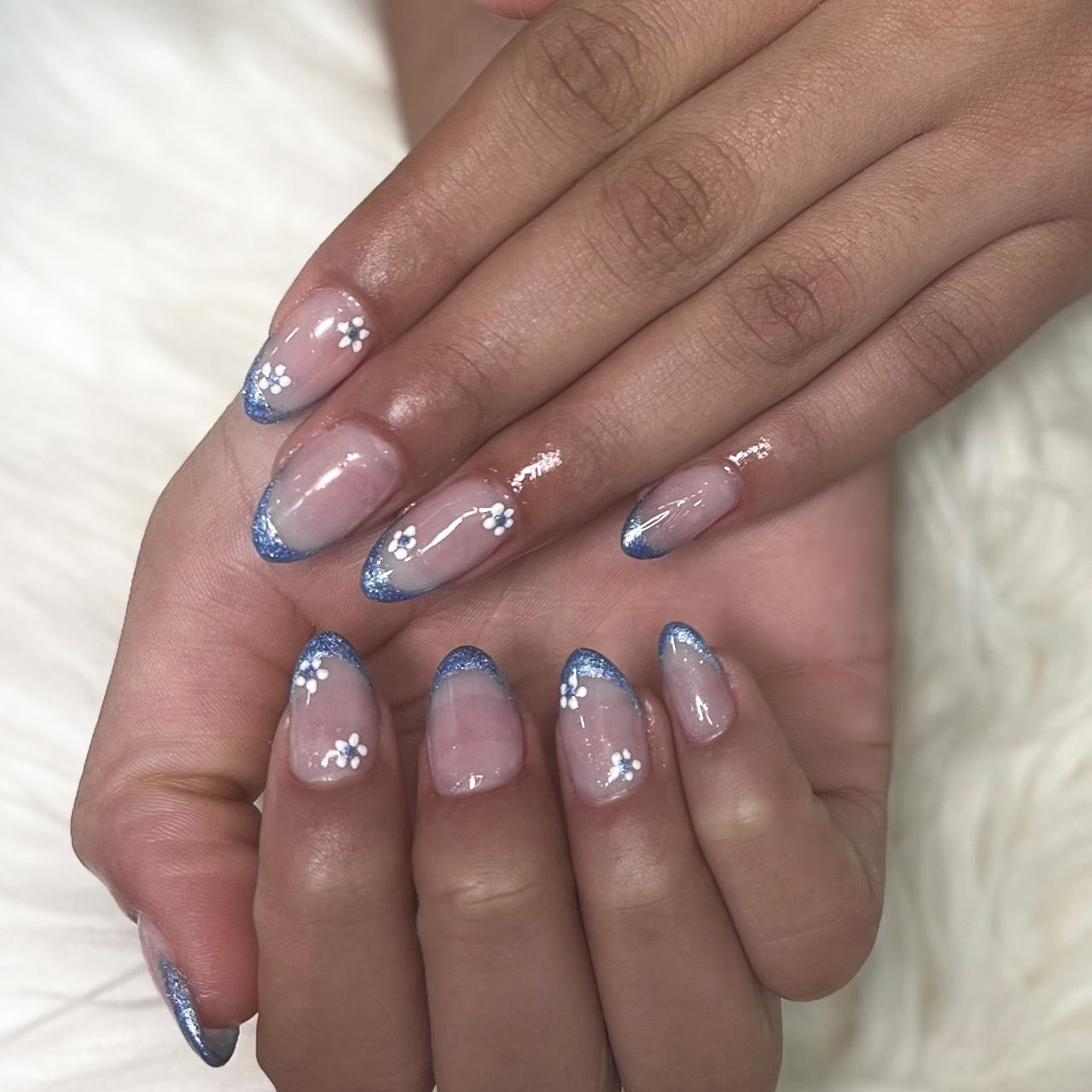 Nail art azul com flores brancas